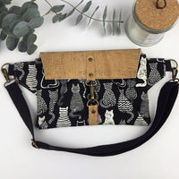 Belt bag/ sling back with black and white cats and a cork flap.