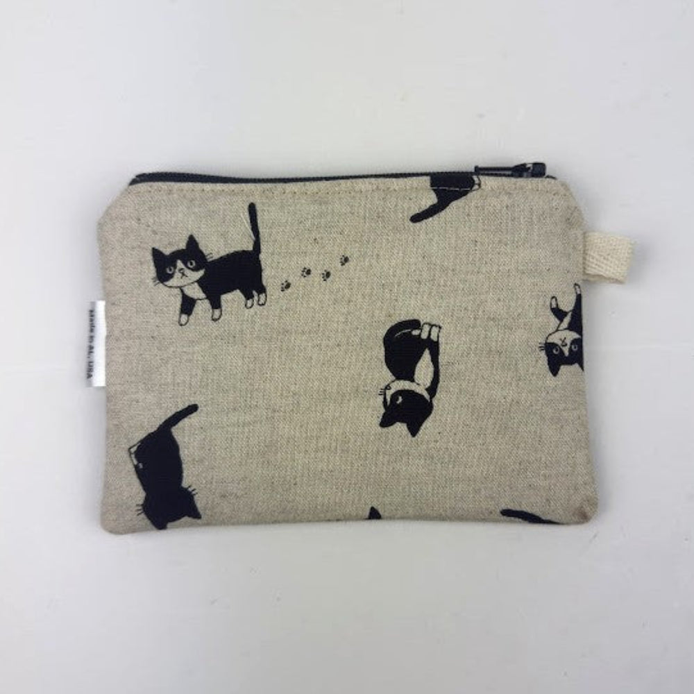 Fabric pouch with black cat illustrations on a beige background