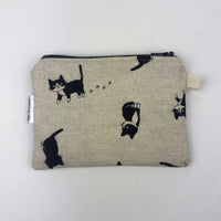 Fabric pouch with black cat illustrations on a beige background