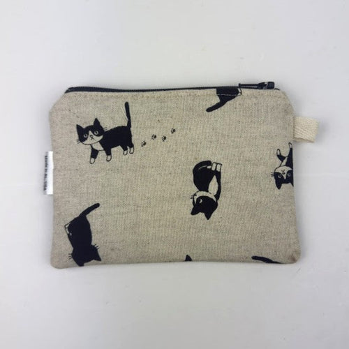 Fabric pouch with black cat illustrations on a beige background